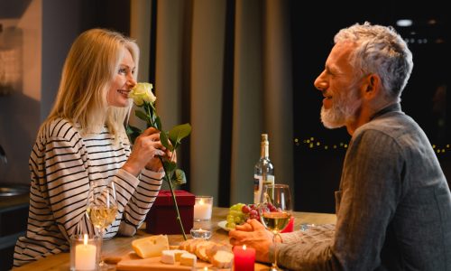 Happy,Middle-aged,Woman,Enjoying,The,Rose,Fragrance,During,Romantic,Dinner